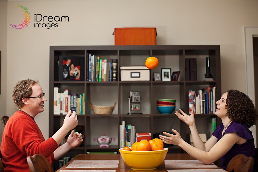 Engaged couple juggles oranges